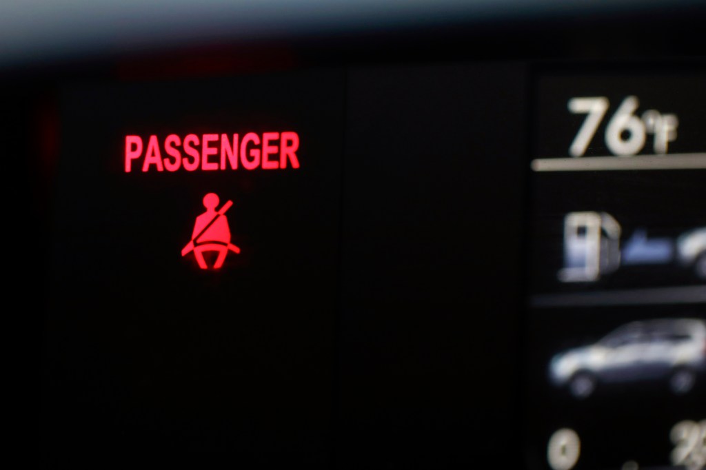 A seat belt warning sign for the right front passenger seat is displayed on a vehicle on Monday, Aug. 21, 2023.